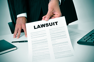 A man with a suit hold a piece of paper that says "lawsuit"