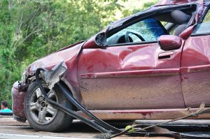 Red car with dented door and front fender