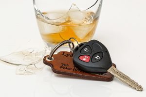 A broken glass of liquor and car keys