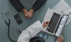 A doctor sitting at a desk with a patient