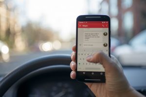 A person texting behind the wheel of a car