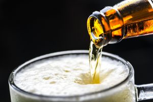 A bottle of beer being poured into a glass