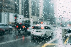 raindrops on a window show a wet congested roadyway