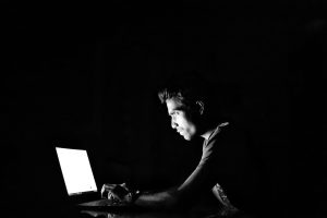 a man using a computer in a dark room