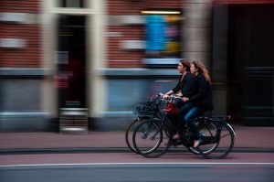 Two cyclists biking on a street