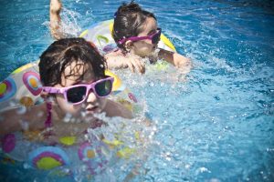 Two young girls swimming in a pool