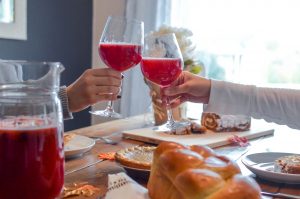 People toasting with drinks over a Thanksgiving table
