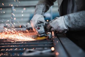 A worker using a grinder